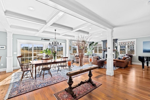 sunroom with beam ceiling, a notable chandelier, and ornate columns