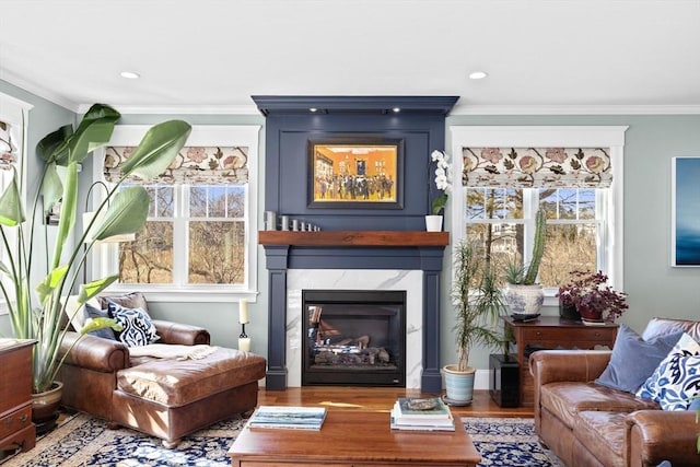 sitting room with recessed lighting, a high end fireplace, wood finished floors, and crown molding