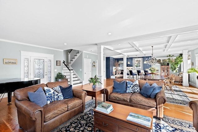 living room featuring beam ceiling, light wood-style flooring, coffered ceiling, decorative columns, and stairs