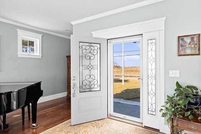 foyer entrance with crown molding, wood finished floors, and baseboards