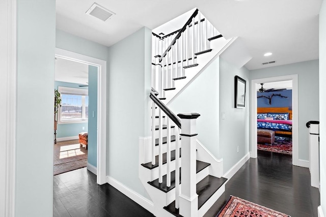 staircase with a ceiling fan, wood finished floors, visible vents, and baseboards