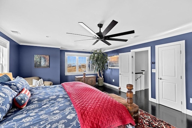 bedroom featuring baseboards, wood finished floors, visible vents, and ornamental molding