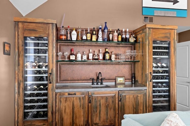 bar with wine cooler, visible vents, wet bar, and lofted ceiling