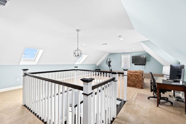 office with visible vents, baseboards, vaulted ceiling with skylight, and carpet flooring