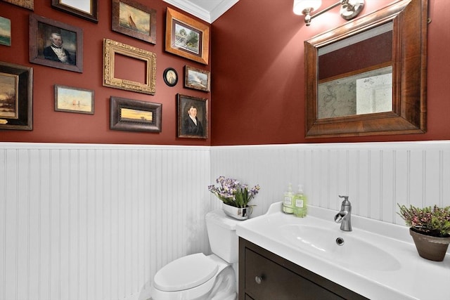 bathroom featuring vanity, toilet, and wainscoting