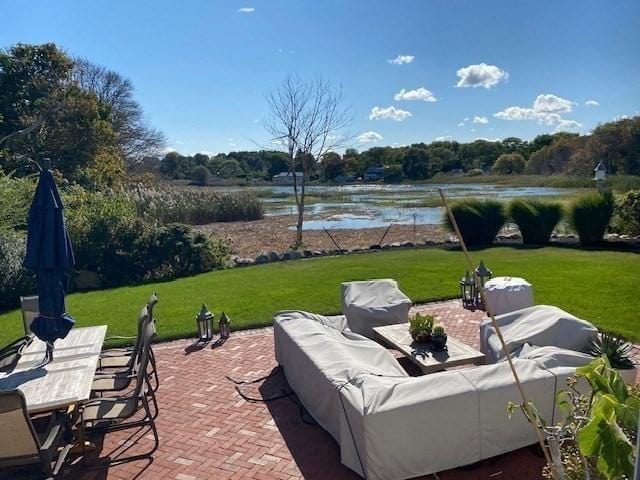 view of patio with an outdoor living space and a water view