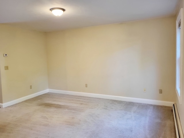 empty room featuring a baseboard radiator and carpet