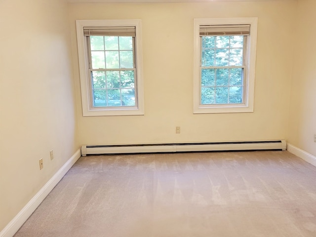 carpeted spare room with plenty of natural light and a baseboard radiator