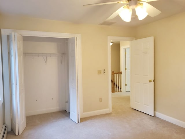 unfurnished bedroom with a baseboard heating unit, ceiling fan, light colored carpet, and a closet