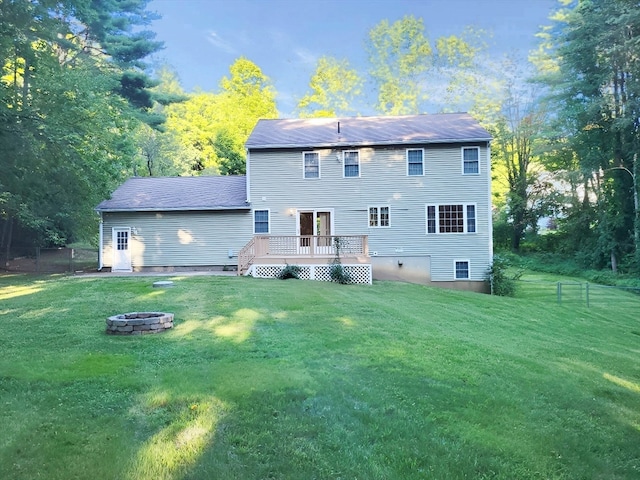 back of house with a yard, a fire pit, and a deck