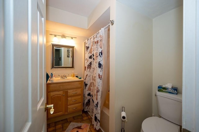 full bath with toilet, vanity, stone finish flooring, and shower / tub combo with curtain