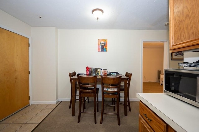 dining space featuring baseboards and light tile patterned flooring