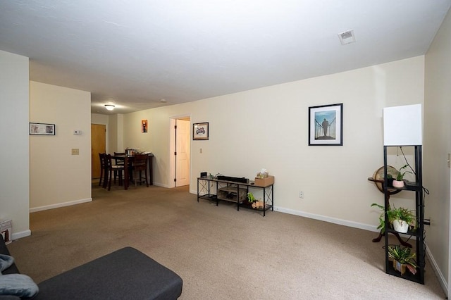 sitting room featuring carpet floors and baseboards