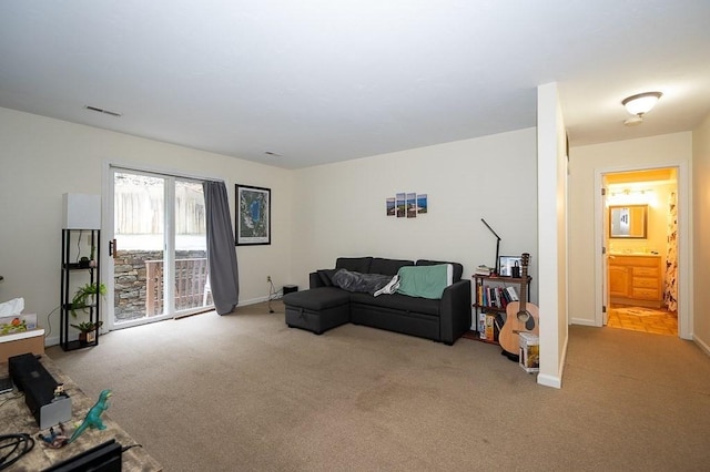 living area featuring light colored carpet and baseboards