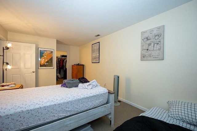 bedroom with carpet floors, a walk in closet, baseboards, and a closet