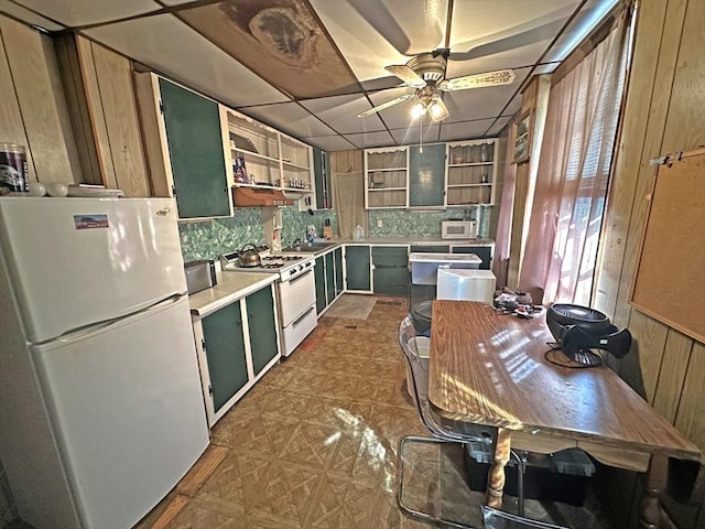 kitchen with white appliances, open shelves, green cabinets, ceiling fan, and tasteful backsplash