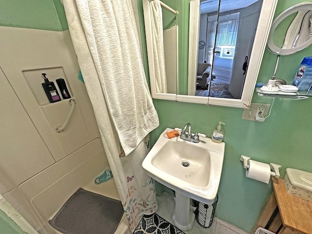 full bath with a shower stall and a sink