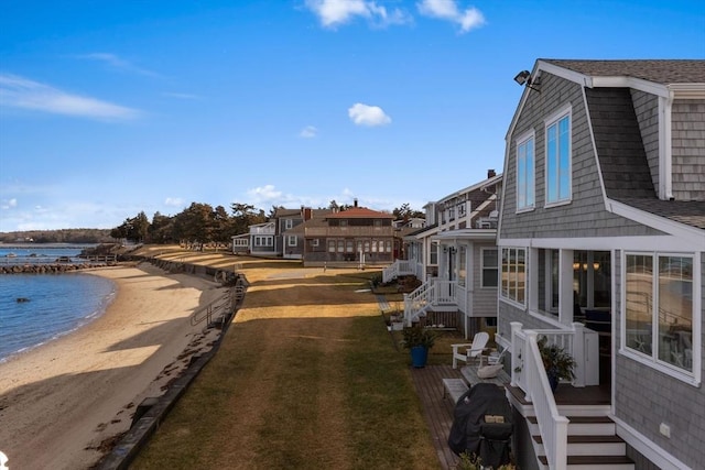 exterior space with a water view and a beach view