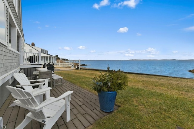 deck with a water view, a yard, and a patio area