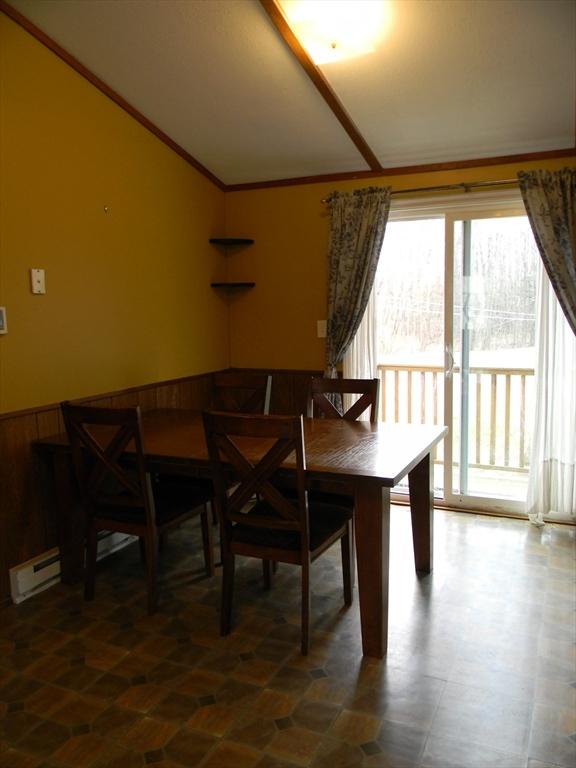 dining area featuring crown molding, a wainscoted wall, and a baseboard heating unit
