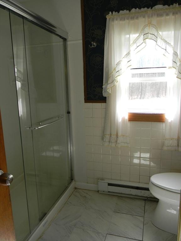 full bath featuring marble finish floor, toilet, tile walls, a baseboard heating unit, and a shower stall