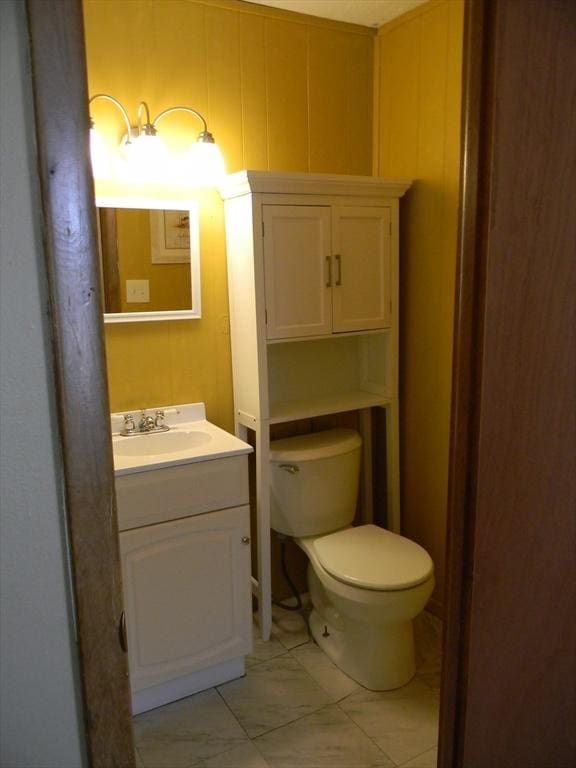 bathroom with toilet, tile patterned floors, and vanity
