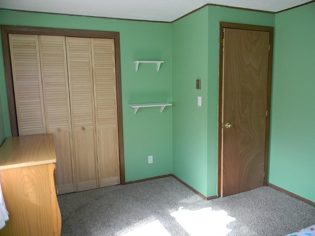 unfurnished bedroom featuring carpet floors, baseboards, and a closet