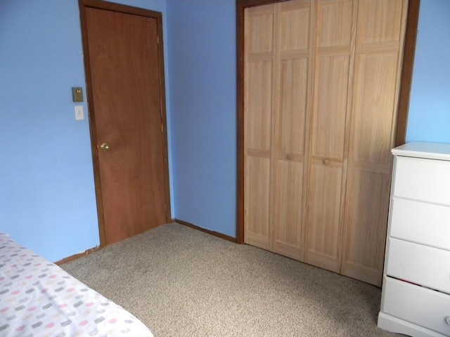 unfurnished bedroom featuring baseboards, carpet, and a closet