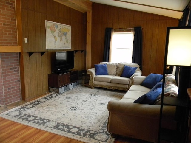 living area featuring wood walls, wood finished floors, and vaulted ceiling