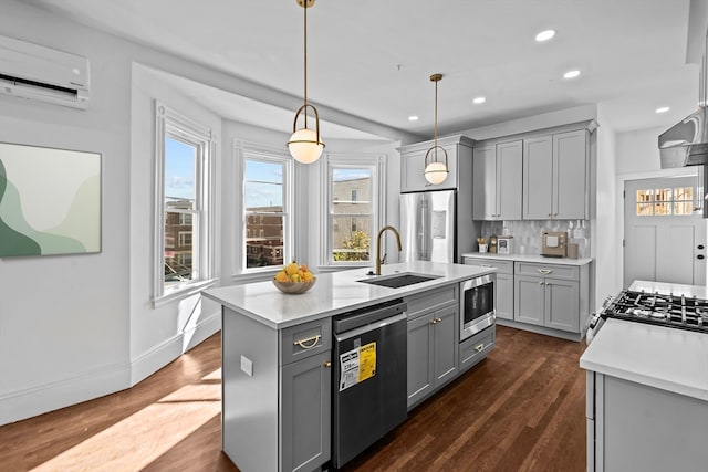 kitchen featuring gray cabinets, sink, stainless steel appliances, and hanging light fixtures