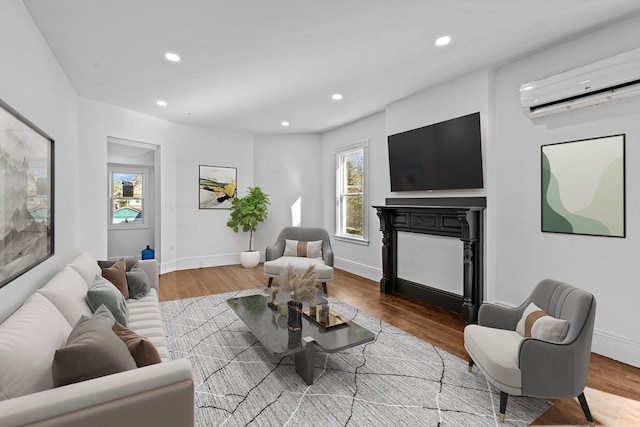 living room with a wall mounted AC and hardwood / wood-style flooring