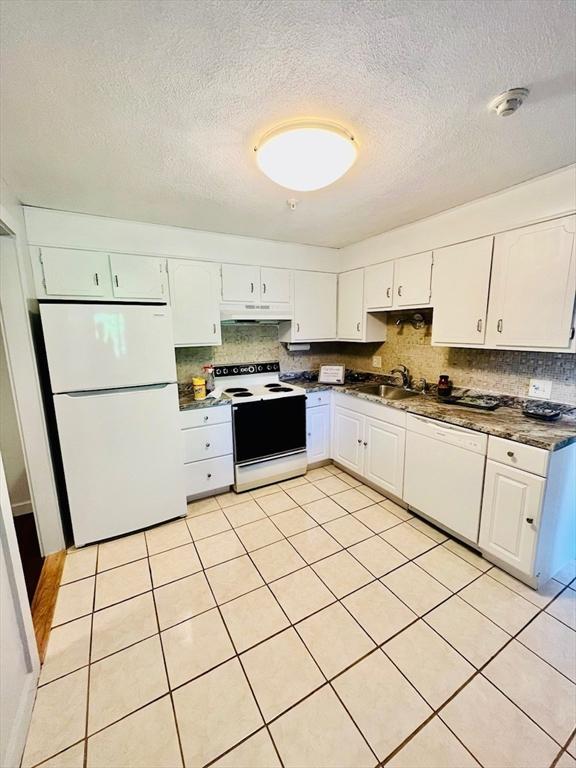 kitchen with white cabinetry, sink, white appliances, and tasteful backsplash