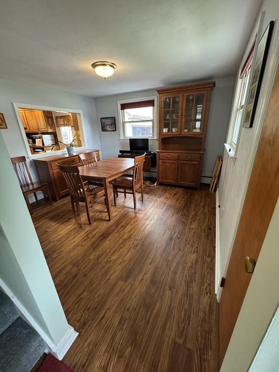 dining area with dark wood-style floors and a baseboard heating unit