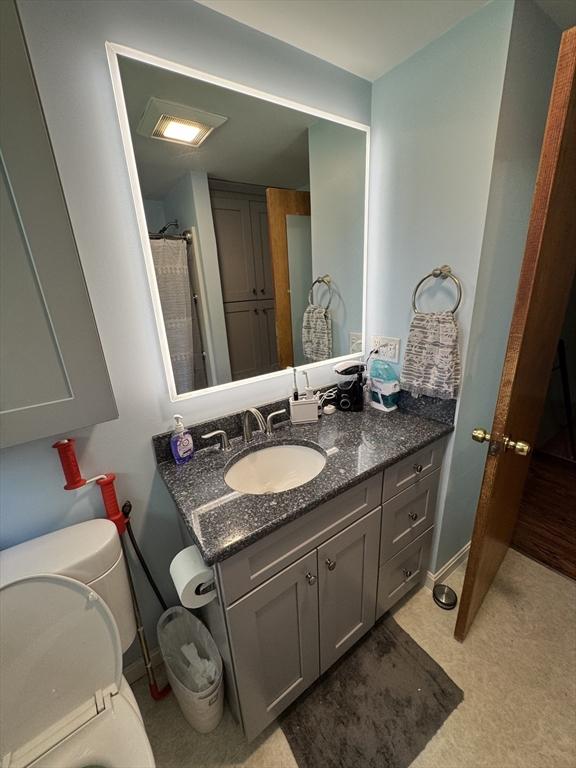 bathroom featuring vanity, baseboards, and toilet