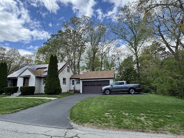 view of front facade featuring a front lawn, an attached garage, driveway, and solar panels