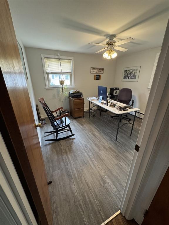office area featuring wood finished floors, a ceiling fan, and baseboards