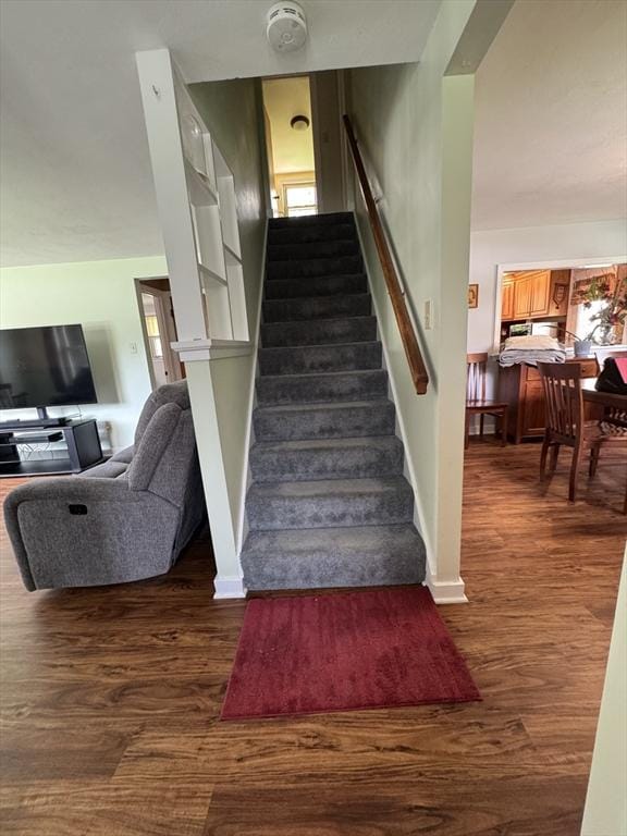 staircase with plenty of natural light, wood finished floors, and baseboards