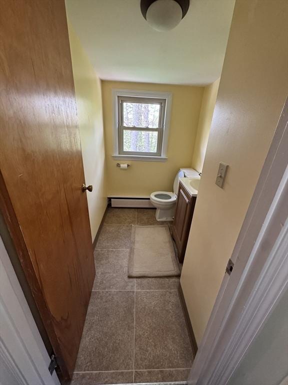 bathroom with a baseboard radiator, tile patterned floors, toilet, vanity, and baseboards