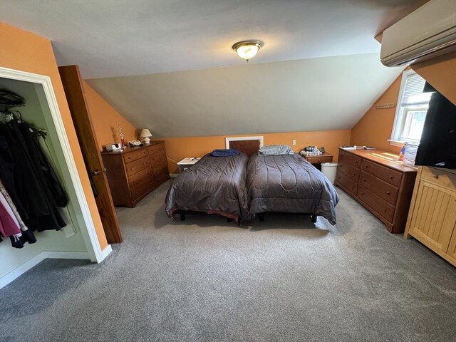 bedroom with a wall mounted air conditioner, vaulted ceiling, light colored carpet, and baseboards