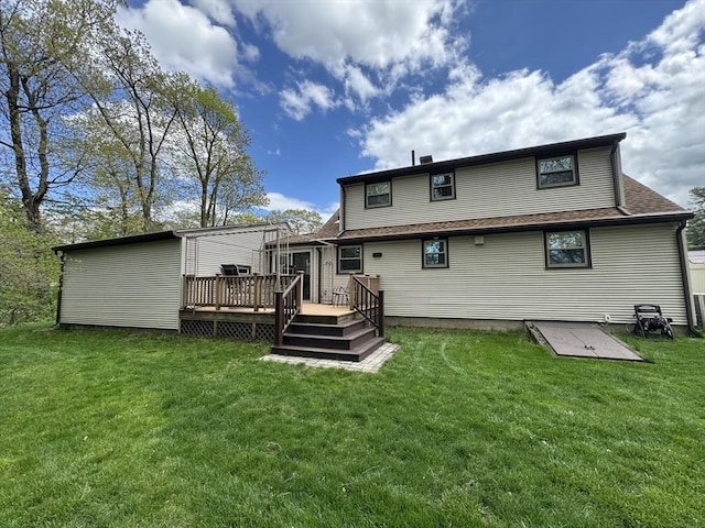 rear view of house with a deck, a yard, and a shingled roof