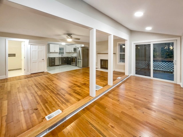 interior space featuring lofted ceiling, ceiling fan, and light wood-type flooring