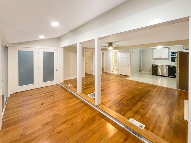 workout area with light wood-type flooring, ceiling fan, and lofted ceiling