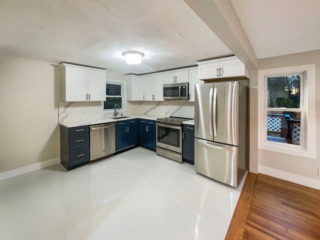 kitchen featuring white cabinetry, sink, blue cabinets, and appliances with stainless steel finishes