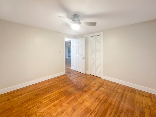 unfurnished bedroom featuring a closet, hardwood / wood-style floors, and ceiling fan