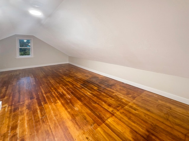 additional living space with vaulted ceiling and hardwood / wood-style floors