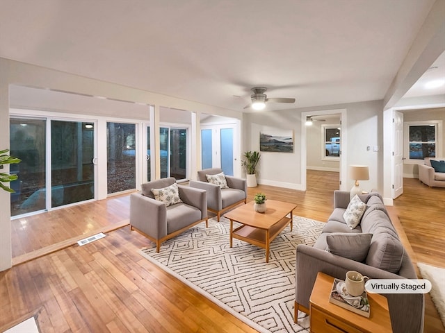 living room with ceiling fan and light wood-type flooring