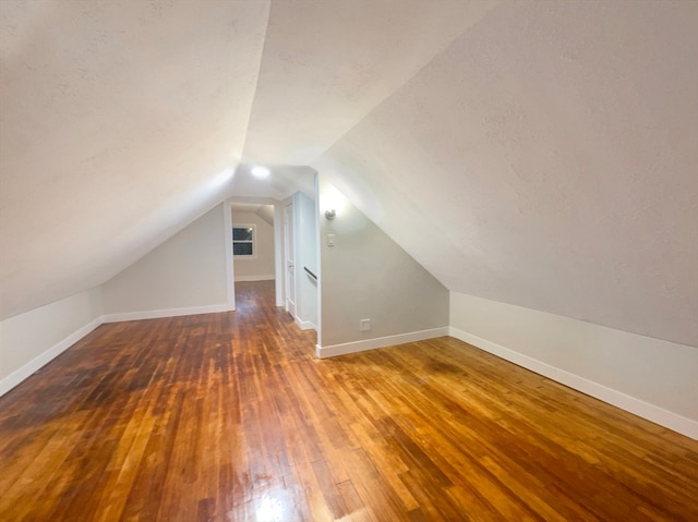 bonus room featuring dark hardwood / wood-style floors and vaulted ceiling