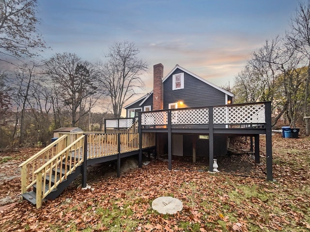 back house at dusk with a deck