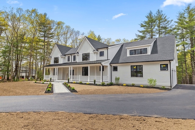 modern farmhouse featuring covered porch and a garage