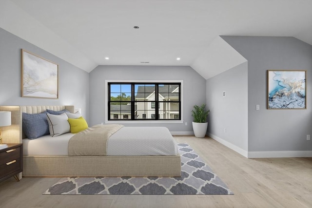 bedroom with lofted ceiling and light wood-type flooring